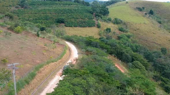 Aerial View of 4X4 Car on Dusty Road in the Green Valley in Tropical Country