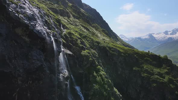 Water Flows Down the Slope of a Mountain Drops Splash From a Huge Rock