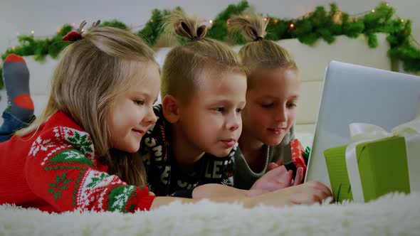 New Year's Concept Children Lie Couch Christmas Clothes Make Online Call Laptop