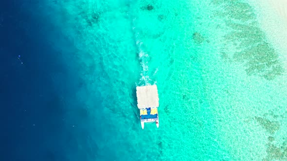 Natural overhead island view of a sandy white paradise beach and blue sea background in colourful 4K