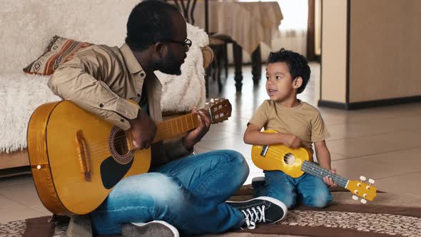 Man and his son playing guitars and singing song