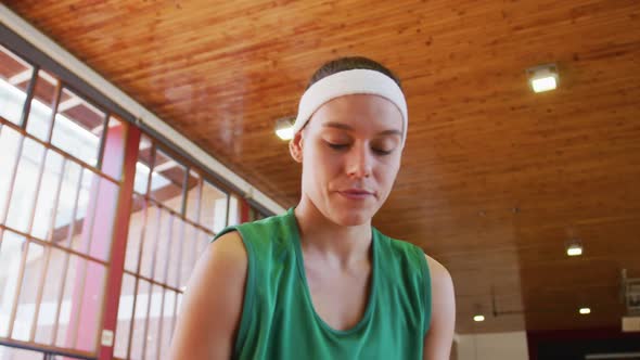 Caucasian female basketball player dribbling and shooting ball