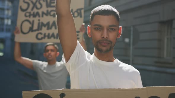 Two mixed race men on a protest march holding placards raising hands and shouting