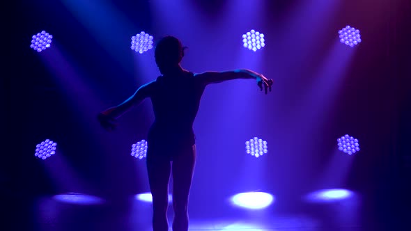 Professional Ballerina in Black Bodysuit Gracefully Dancing Ballet. Shot in Dynamic Spotlights and