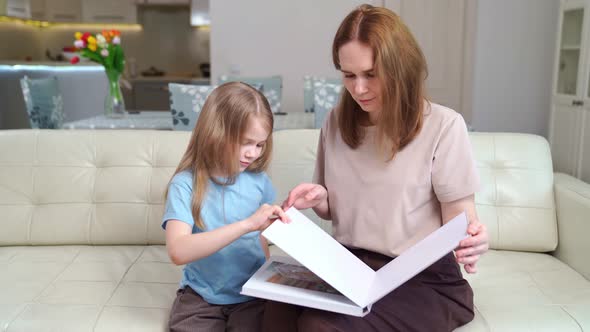 Mother and Daughter Looking a Book with Photos From a Family Photo Shoot