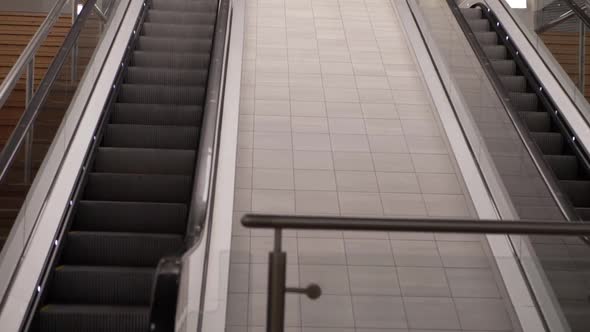 Escalator in empty shopping center mall wide panning shot