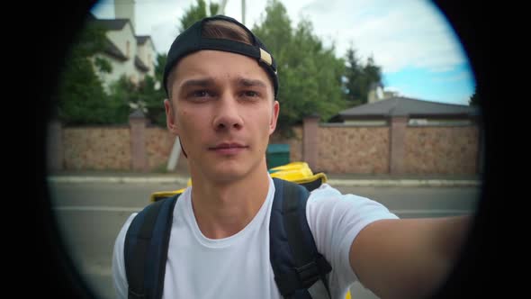 Peephole POV of Young Delivery Boy Ringing Door Bell Standing on Suburban Street