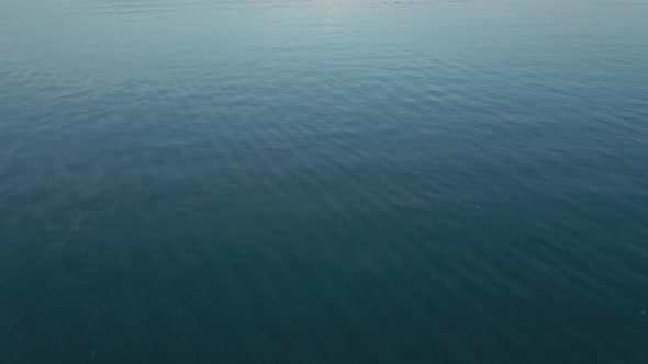 Cinematic Camera Flight Over a Large Blue Lake at a Pink Sunset