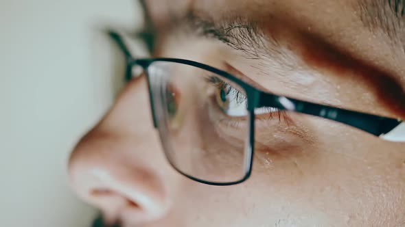 Close-up of the Eye of a Man with Glasses Who Works at the Computer