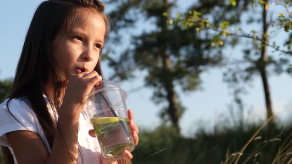 Happy girl drinking a drink in nature.