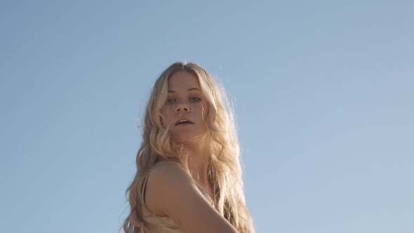 Beautiful Woman Dancing In Gold Under Blue Sky