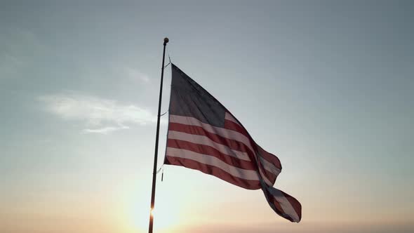 The American Flag Fluttering in the Wind at Sunset