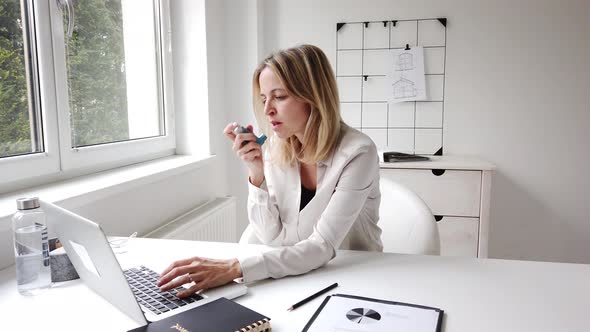 Coughing businesswoman using inhalator in home office