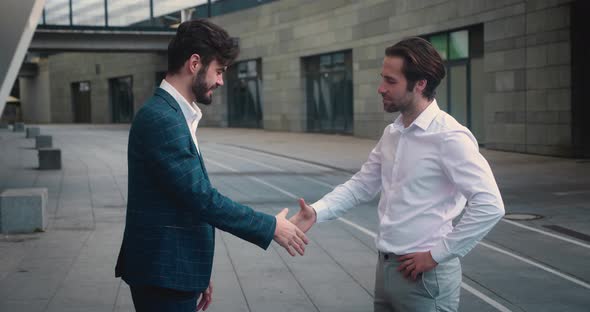 Male and His Business Partner Colleague Shaking Hands in Street Business Cooperation Meeting