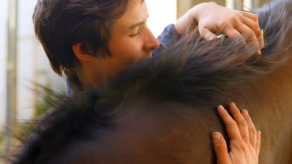 Woman embracing horse at stable