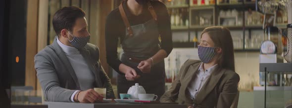 Female waiter in cafe bringing beverages