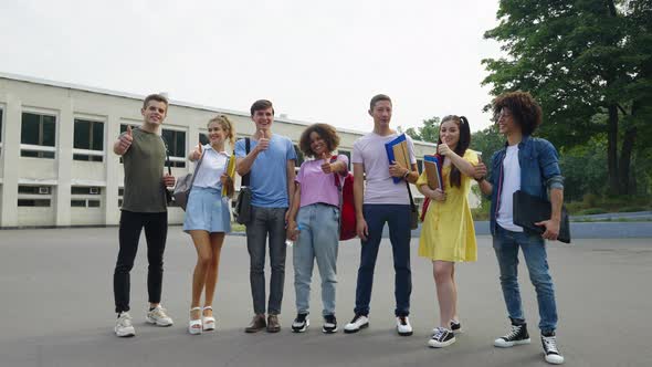 Happy Students Showing Thumbs Up Near College