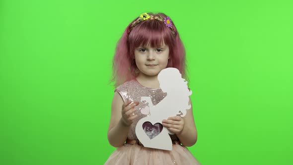 Girl Holds Holds Wooden Photo Frame in the Form of Pregnant Woman. Mother's Day