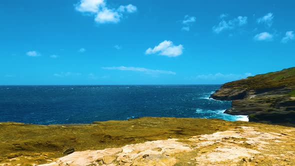 Cliff to the ocean in Honolulu, Oahu. Lanai lookout in Hawaii. Blue ocean waves hit mountain rocks.