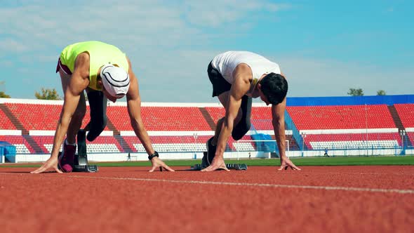 Two Runners with Artificial Legs Are Practicing