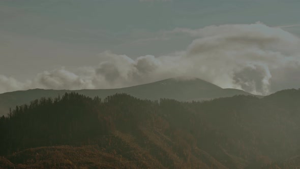 Beautiful Misty Foggy Landscape with Dark Forest on Mountain Among Low Clouds