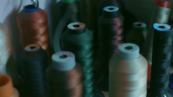 Spools of Thread for Sewing Shoes in Dark Colors Stand on a Shelf