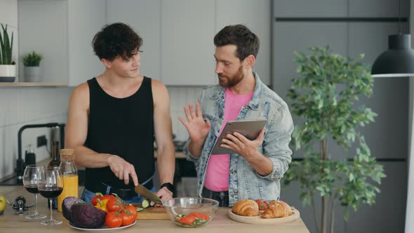 Lgbt Couple Standing Together in Their New Apartment in the Kitchen and Cooking One Partner Showing