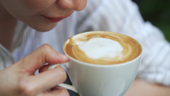 4K Close up of Asian woman drinking coffee from coffee cup at cafe