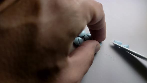 The patient divides the pill into parts with a knife before taking it for treatment