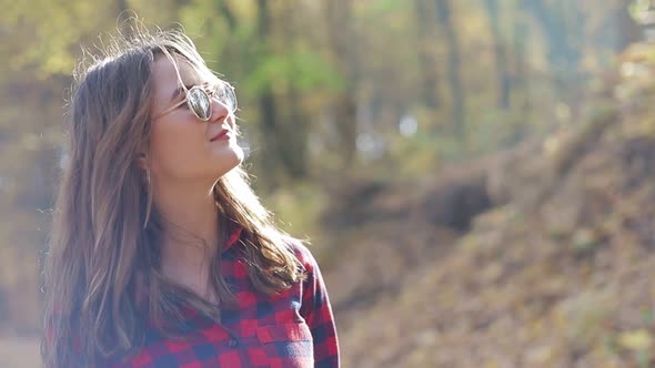 Girl walking in the woods with a bag on her back, girl in a red shirt