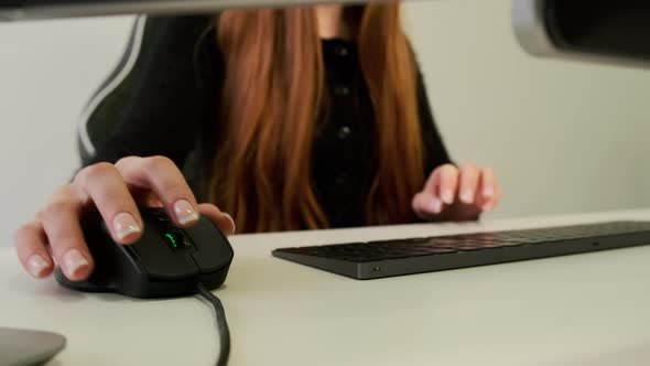 Close Up Vieq of Woman Hand Scrolling Mouse and Typing Text on Keyboard on the Computer Desk