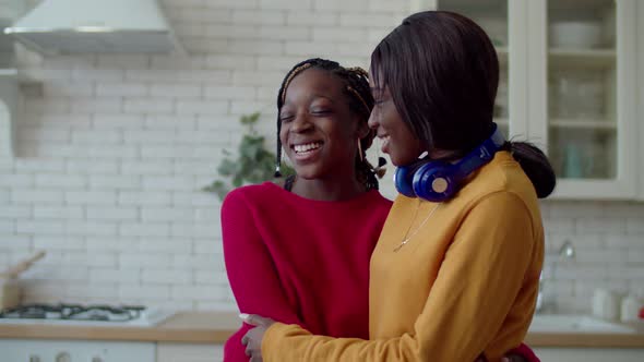 Portrait of Smiling Black Teenager Sisters Bonding Indoors