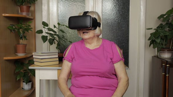 Senior Grandmother Woman in Virtual Headset Glasses Watching 3d Video in 360 Vr Helmet at Home