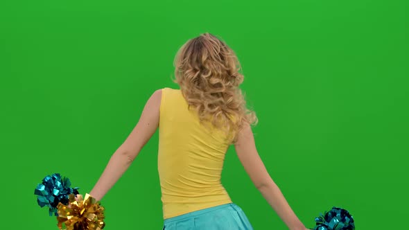 Rehearsal of a Dance of a Cheerleader in a Yellowblue Uniform on a Green Screen in a Studio