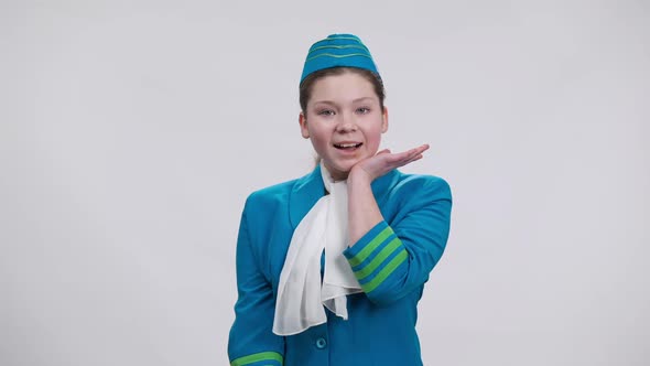 Excited Caucasian Girl in Stewardess Uniform Putting Hand to Chin Smiling Looking at Camera