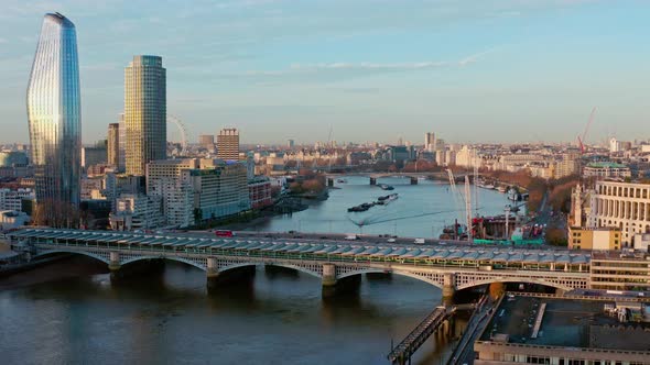 Aerial dolly forward looking west over Blackfriars bridge towards London eye and House of parliament