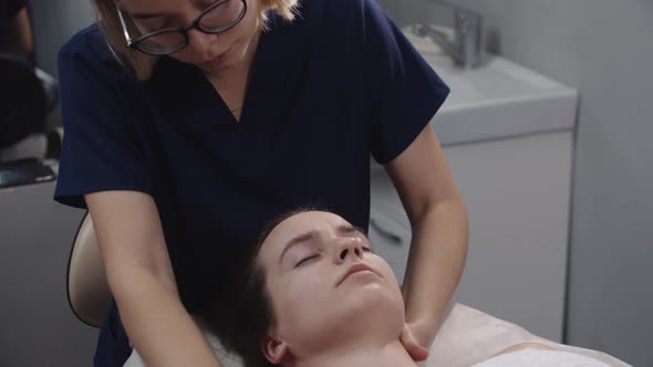 Young Woman Massagist Doing Relaxing the Neck and Shoulders Using Her Hands on Her Female Client