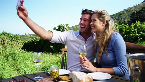 Happy couple taking selfie with mobile phone while having wine 4k