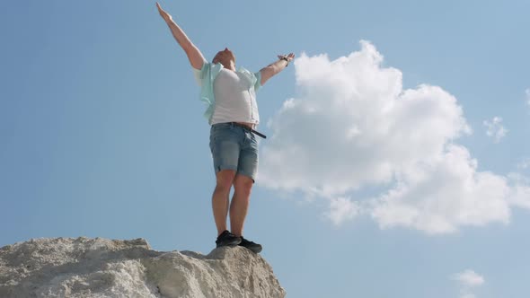 Happy Man Looks Up To The Sky While Standing On A High Mountain