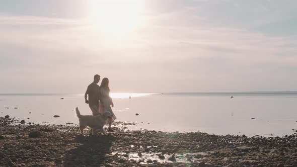 Couple Walking Dog by Seashore