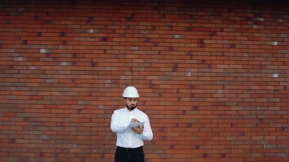 Helmet Worker Makes Notes