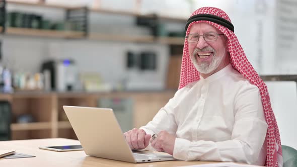 Senior Old Arab Businessman with Laptop Smiling at Camera 