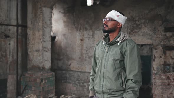 Refugee Man with Bandaged Head at Abandoned House