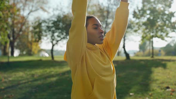 Girl Doing Breathing Exercises at the City Park in the Autumn Morning