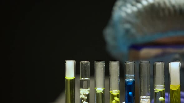 Researcher Dripping Liquid in Tubes With Bubbling Substances