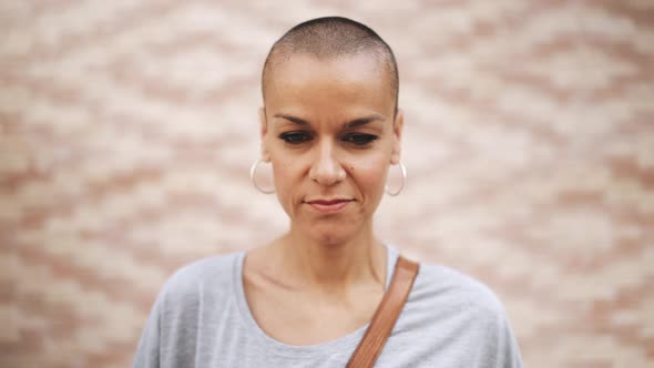 Handsome bald woman wearing t-shirt looking at the camera