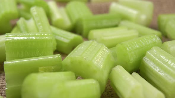 Slices chopped fresh celery stalk on a burlap rough tablecloth. Macro