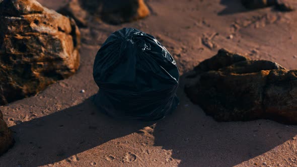 Black Plastic Garbage Bags Full of Trash on the Beach