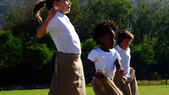 Children playing a sack race in park