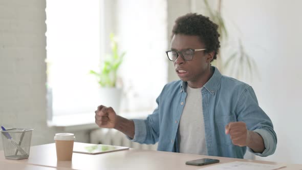 Tense Young African Man Feeling Frustrated While Sitting in Office